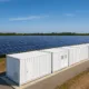 Solar farm with containerized battery storage system.