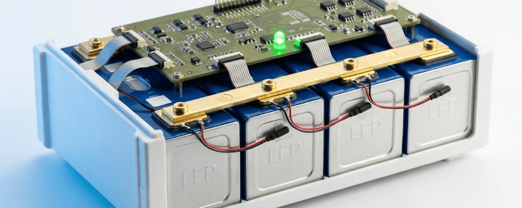  SunLith Energy LiFePO4 prismatic battery module with BMS circuit board mounted above the cells, showing temperature sensors and busbar connections — BMS for LiFePO4 batteries guide by Sunlith Energy