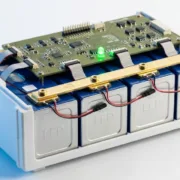 bms-for-lifepo4-batteries-feature-sunlith - SunLith Energy SunLith Energy LiFePO4 prismatic battery module with BMS circuit board mounted above the cells, showing temperature sensors and busbar connections — BMS for LiFePO4 batteries guide by Sunlith Energy