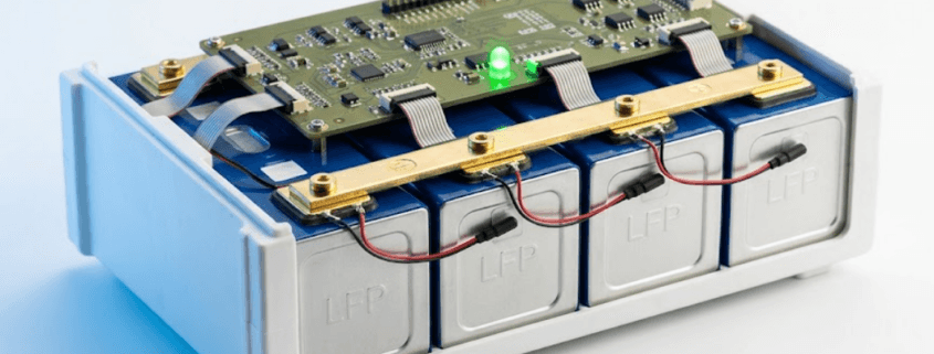 LiFePO4 prismatic battery module with BMS circuit board mounted above the cells, showing temperature sensors and busbar connections — BMS for LiFePO4 batteries guide by Sunlith Energy