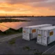 SunLith Energy Large BESS containers alongside a utility-scale solar farm illustrating BESS oversizing strategy