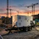 Mobile BESS: The Complete Guide to Trailer-Mounted Battery Storage - SunLith Energy SunLith Energy Mobile BESS trailer deployed on a construction site providing temporary power